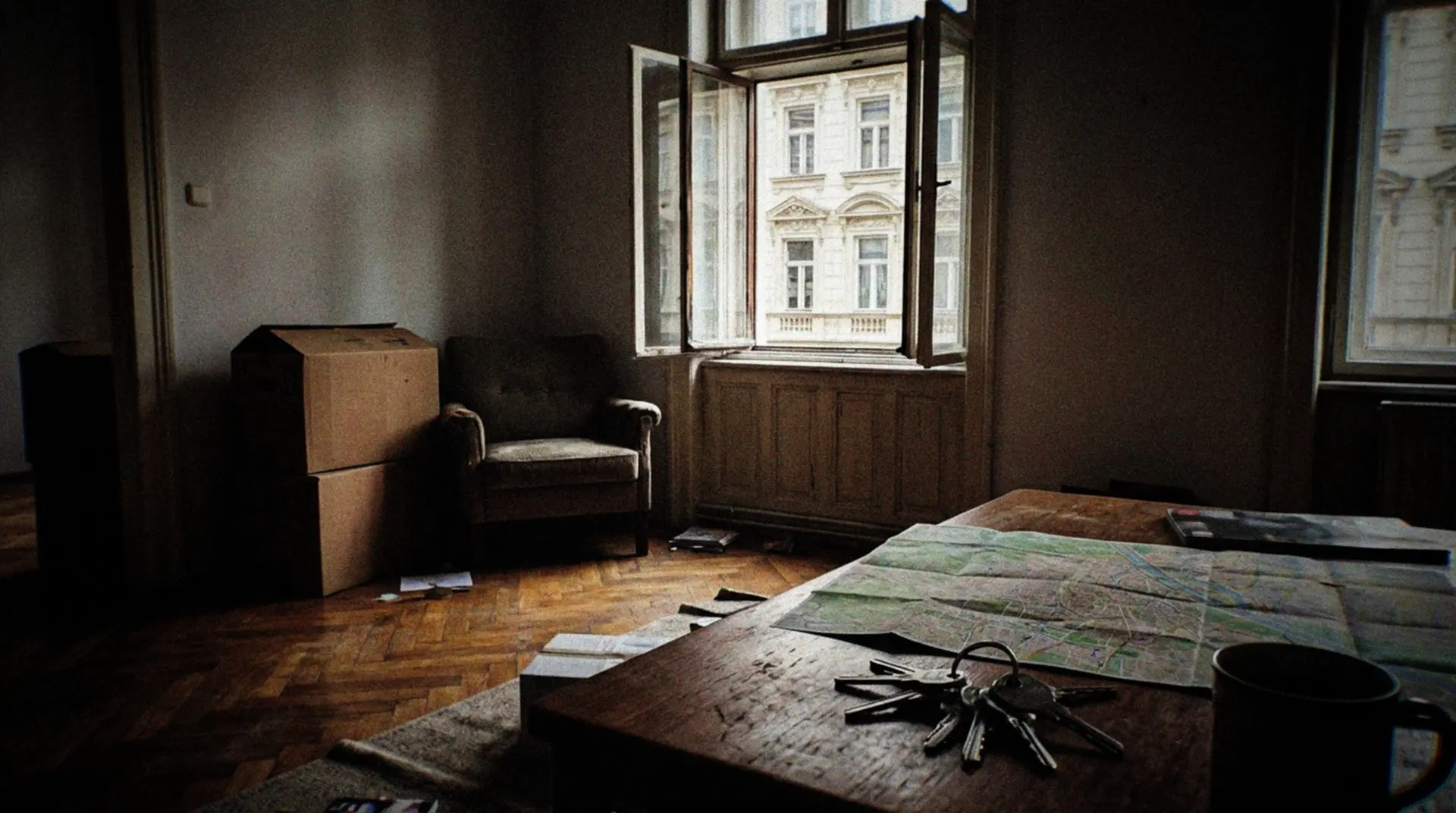 A casual, slightly blurry smartphone photo of a cozy Viennese apartment living room with moving boxes in the corner. An open window reveals a glimpse of traditional Viennese architecture across the street. A coffee table holds a map of Vienna, a ring of keys, and a half-empty coffee cup. The afternoon light casts natural shadows across the hardwood floor, highlighting the transition between packed and unpacked belongings. The scene captures the authentic, unpolished reality of an expat's first apartment in Vienna.
